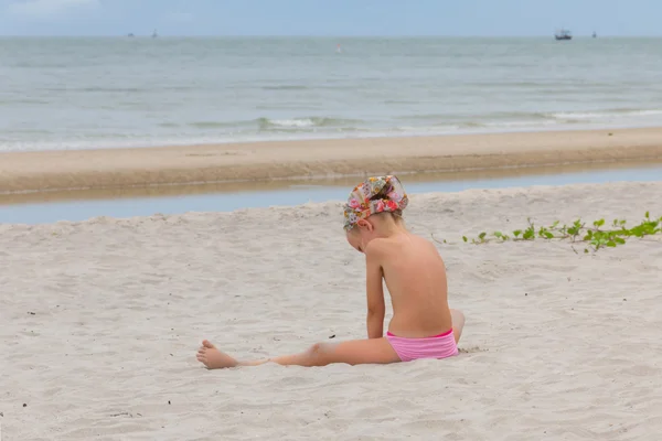 Спина ребенка, играющего с песком на пляже летом Лицензионные Стоковые Изображения