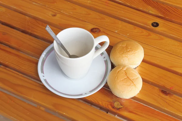 空一杯の黄色の木のテーブルでコーヒーとパンします。 — ストック写真