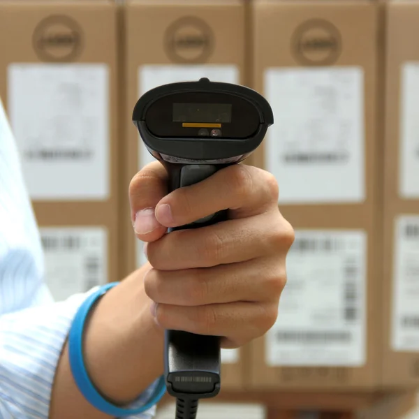 Hoding escáner de código de barras sobre el fondo cajas —  Fotos de Stock