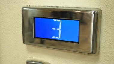 Asansör tahtası yerde. Asansör iniyor. Rakamlı ve mavi ekran düğmesi