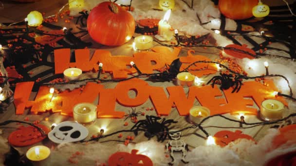 Calabazas de Halloween y decoraciones con caras de miedo, esqueleto, telarañas, arañas y velas encendidas — Vídeo de stock