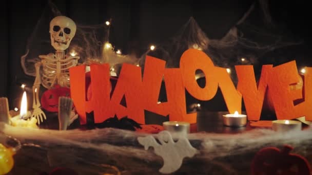 Calabazas de Halloween y esqueleto con cara de miedo en habitación oscura con velas y luces. Saludos de Halloween — Vídeos de Stock