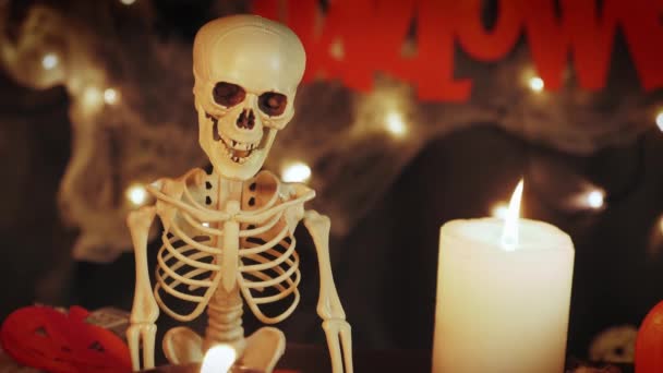 Dia dos Mortos e celebração de Halloween. Esqueleto com velas acesas contra fundo escuro noite — Vídeo de Stock