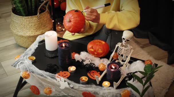 Halloween jelmezbál. Lány boszorkány kalap kezében tök és festés kísérteties arc — Stock videók