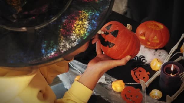 Хэллоуин. Женщина рисует страшное тыквенное лицо для вечеринки на Хэллоуин — стоковое видео