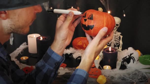 Przygotowuję dynię halloween. Ręce malują przerażającą dynię halloween. Wesołego Halloween — Wideo stockowe