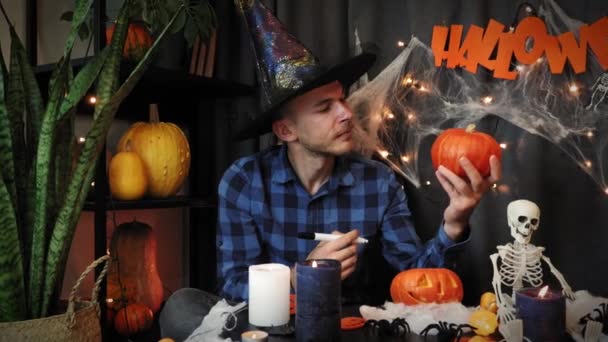 Boldog Halloweent! Jóképű izgatott férfi rajz kísérteties arc tök, felkészülés Halloween — Stock videók