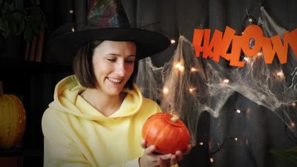 Glad halloween. Glada leende hona som håller ristade pumpa i händerna. Halloween dekorationer — Stockvideo