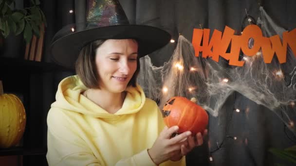 Conceito de Halloween. Jovem fêmea segura em suas mãos abóbora assustadora. Feliz Dia das Bruxas — Vídeo de Stock