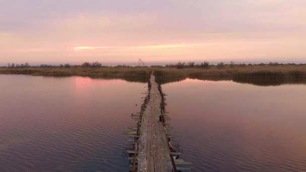 Prachtige roze zonsondergang. Lege brug door estuarium bij zonsopgang. Rustige wateroppervlakte — Stockvideo