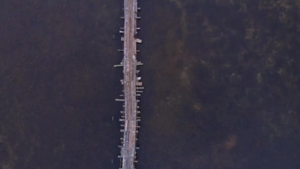 Starý rybářský dřevěný most na jezeře s klidnou čistou vodou. Krásný východ slunce na jezeře — Stock video