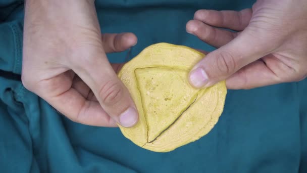 Manos rompiendo caramelos Dalgona en forma de triángulo. Hombre rompe galleta de azúcar morena — Vídeo de stock