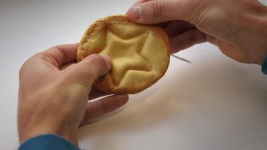 Dalgona kurabiyesi. Kalamar Oyunu. Erkek elleri esmer şekerli karamel şekerini çizer