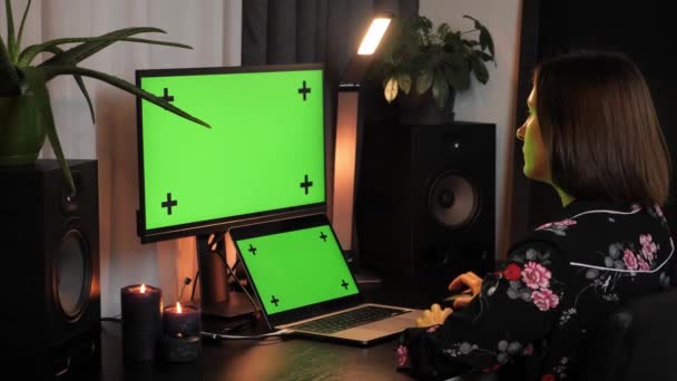 オフィスでモックアップ緑の画面モニターを持つパーソナルコンピュータ上で働く女性 — ストック動画