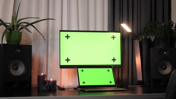 Компьютер и ноутбук с макетом зеленых мониторов стоять на рабочем столе — стоковое видео