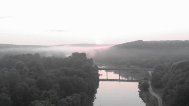 Güneşin doğuşunda sisli ve sakin bir nehir. Güzel doğa manzarası. Ormanda sisli güneş ışığı