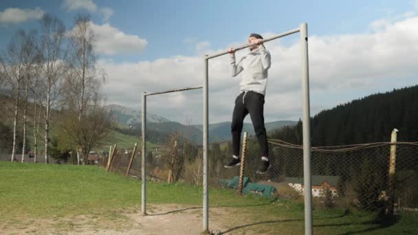 Homme se garer sur la barre horizontale tout en s'entraînant dans le parc de la ville à l'extérieur. Sport actif — Video