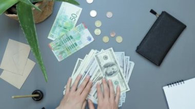 Ofiste para veren bir kadın, üst tabaka. Eller yüz dolarlık banknotları geçiyor.