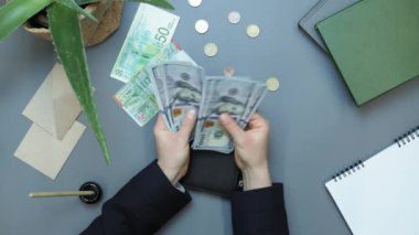 Masadaki cüzdana 100 dolarlık banknotlar koyan kadın. Finans kavramı
