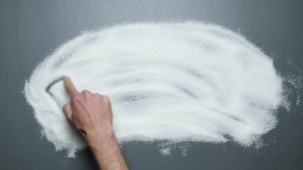 Слово отрута написано на цукрі. Рука пише отруту на цукрі. Зупинити діабет — стокове відео