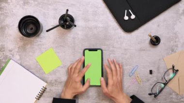 Masada krom anahtarı olan akıllı telefon. Ev telefonunda çalışan bir kadın.