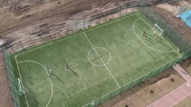 Futbol oynayan çocuklar, futbol sahasında antrenman yapanlar. İnsanlar yazın futbol oynar.
