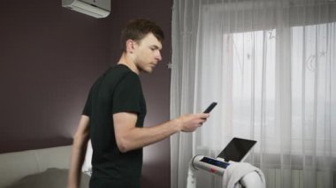 Adam evdeki koşu bandında egzersiz yapıyor, covid-19 salgınında karantinada sağlıklı kalıyor.