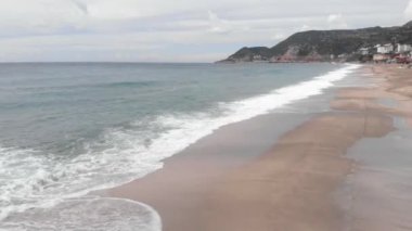Deniz dalgaları beyaz kumsalda kırılır. Güzel sahilde okyanus dalgaları