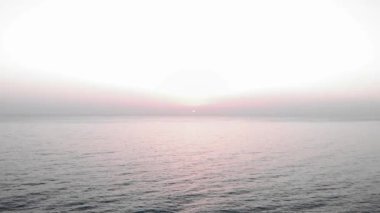 Okyanusta güneş batıyor. Denizde pembe gün batımı. Deniz kıyısında gün batımı. Güneş deniz ufkuna dokunur