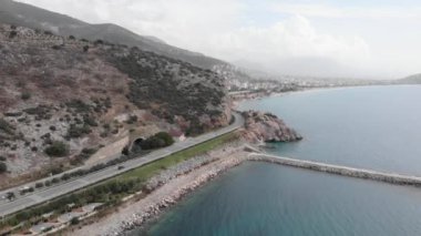 Alanya, Türkiye 'deki sahil şeridi. Araba yolu, şehir ve dağları olan sahil kıyısı