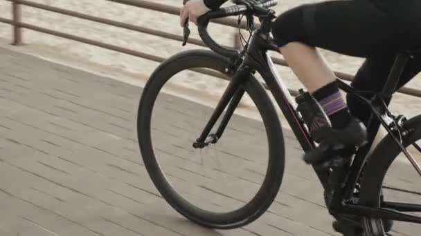 Fit sportive woman rides bicycle on cycle promenade. Cyclist is cycling road bike — Stock Video