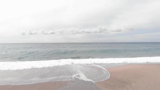 Волны ломаются на пляже. Береговая линия океана с волнами и песчаным пляжем — стоковое видео