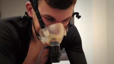 Modern spor laboratuarında bisiklete binen bisikletçi maksimum ses sınavından geçiyor.