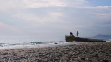 Sahilde balıkçı balıkçılığı. İki balıkçı kıyıda oltayla balık yakalıyor.
