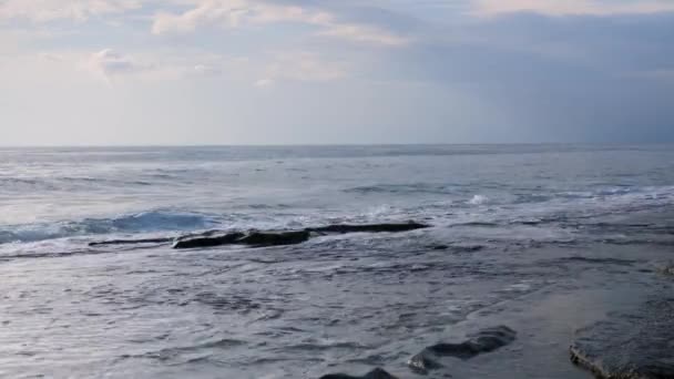 Zee golven crashen op rotsachtig strand. Grote golven spatten en creëren wit schuim — Stockvideo