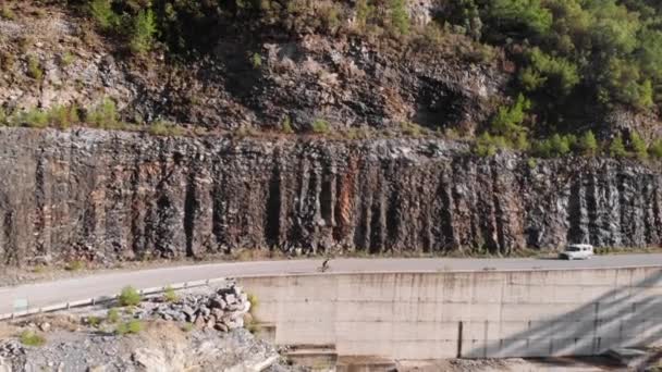 Ciclista profissional montando subida na bicicleta de estrada. Ciclista de estrada sobe switchbacks de montanha — Vídeo de Stock