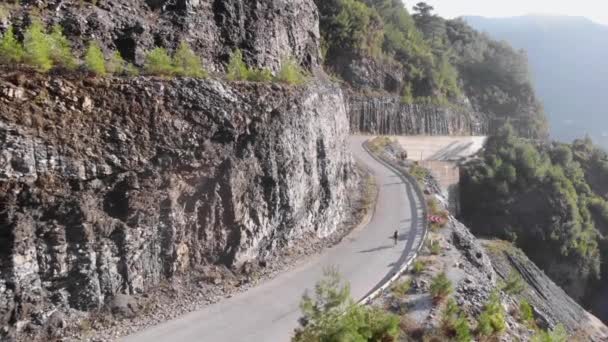 Dağ yoluna tırmanan bir bisikletçi. Atlet dağ geçidinde bisiklet sürüyor. Spor konsepti — Stok video