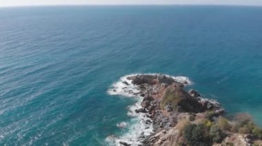 Kayalara çarpan dalgaların oluşturduğu kayalık deniz kıyısı beyaz köpük oluşturur. Okyanus dalgaları kayalara çarpıyor