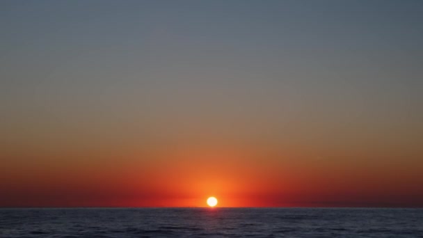 Sonnenuntergang über der Wasseroberfläche. Sonnenuntergang über dem Meer. Wellen und Reflexion des Sonnenlichts bei Sonnenaufgang — Stockvideo