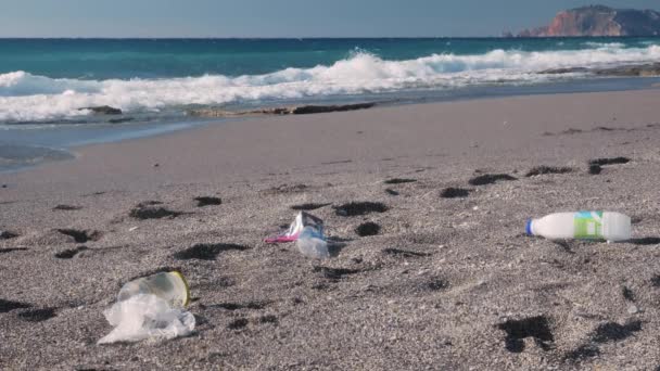 Plastic pollution and environmental problem concept. Used plastic bottles and bags on beach — Vídeo de Stock