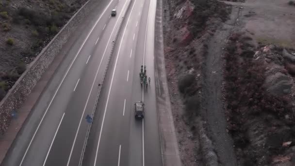 Cyclistes s'entraînant sur la route à travers la colline de montagne accompagné d'une voiture. Équipe cycliste professionnelle à vélo de route — Video