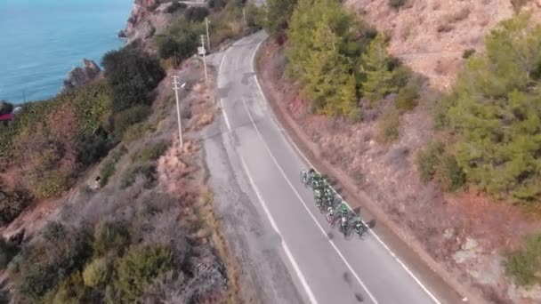 Cyclists cycling on mountain road along coastal. Professional cycling team riding on road bicycles outdoors — Stock videók