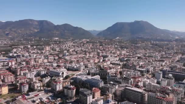 Cidade, montanhas e céu azul no dia ensolarado de verão. Vista aérea panorâmica da grande cidade contra as montanhas — Vídeo de Stock