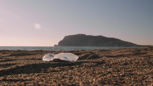 Dobrovolník čistí pláž od odpadků. Žena sbírá plastové láhve na pláži — Stock video