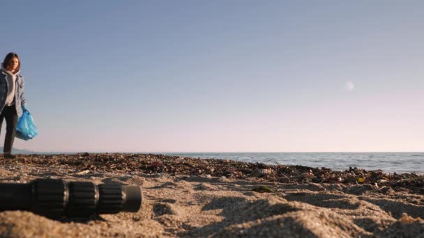 Voluntario recoger basura de plástico en la bolsa en la playa contaminada — Vídeos de Stock