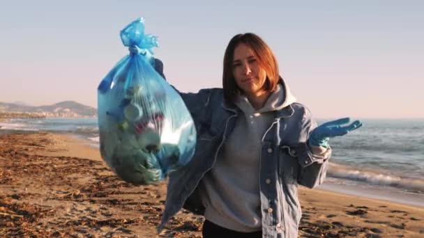 Mujer sosteniendo la bolsa de basura llena de basura de plástico, trastornado y sacudiendo la cabeza — Vídeo de stock