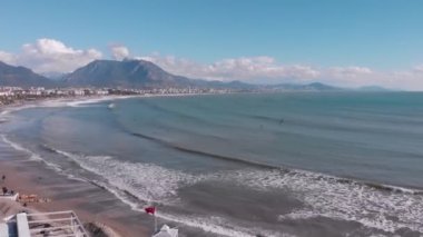 Denizde fırtına. Güneşli bir günde sörf yapan sörfçüler. Alanya 'nın deniz kıyısı