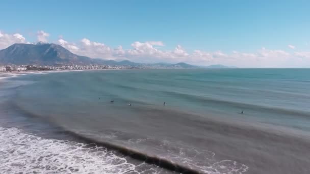 Güneşli bir günde dalgaların dalgalanmasını bekleyen bir grup sörfçü. Okyanus dalgasında sörfçü — Stok video