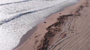 Büyük fırtınadan sonra plaj enkaz ve plastik çöplerle doldu. Dalgalar fırtınadan sonra kumsalda yuvarlanır