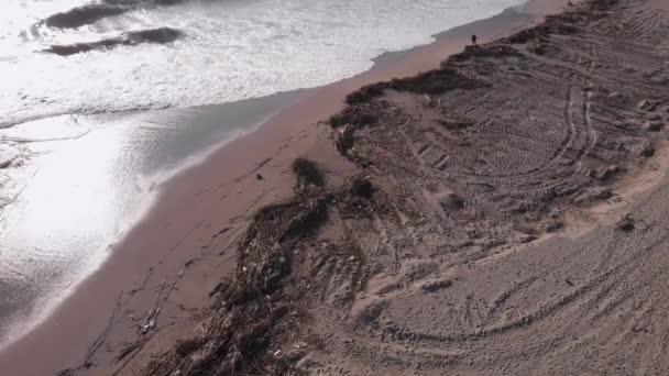 Vol au-dessus de la plage de saleté avec des débris et des déchets en plastique après une forte tempête — Video